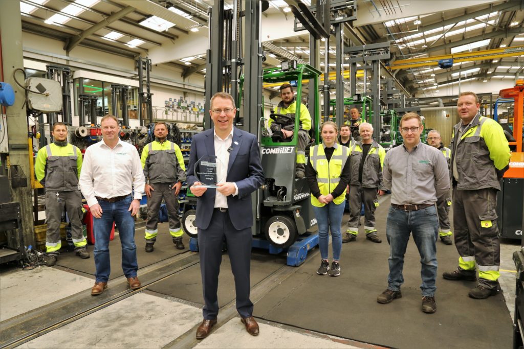 CEO Martin McVicar accepts the Energia Family Business of the Year Award alongside several Combilift employees, two of which are seated in the Combi C-Series Forklifts