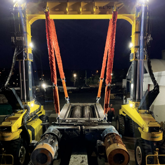 Combilift Straddle Carrier lifting load at night